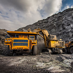 Image shows mining truck and excavator in front view