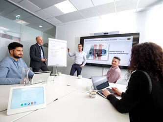 Mitarbeiter im Gespräch am Tisch sitzend