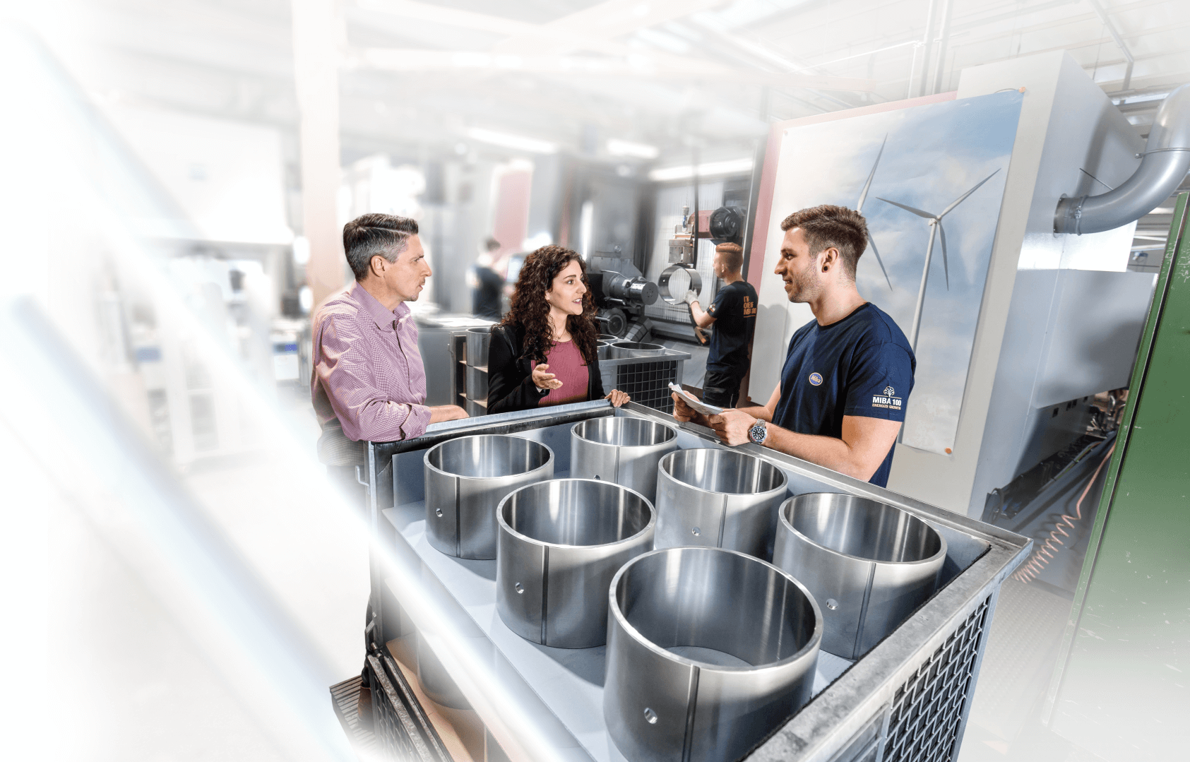 People discussing in a production plant in front of bearings